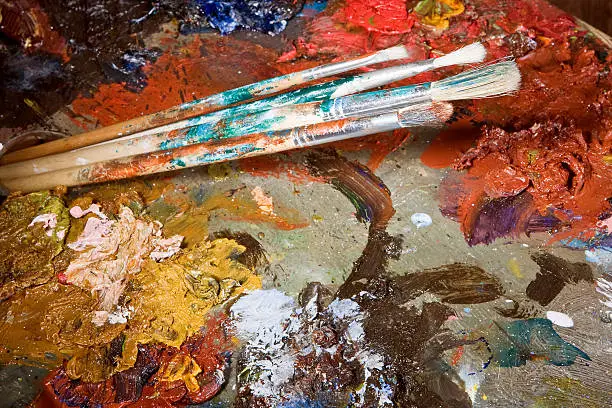 Painter's brushes and colorful almost abstract pallet full of paint