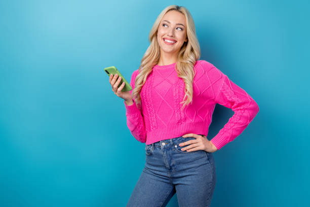istock Photo of dreamy pretty woman dressed knitted pullover communicating modern gadget looking empty space isolated blue color background 1521793831
