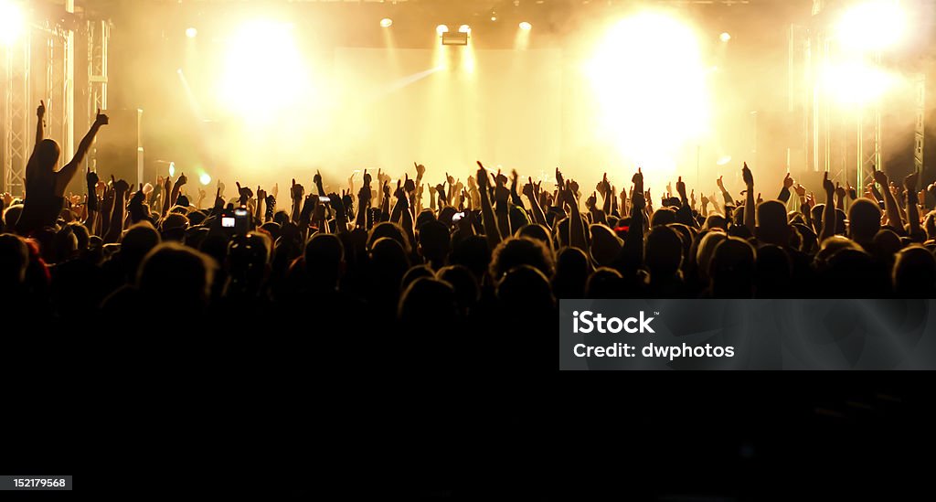 Wide Angle Shot of concert crowd Wide Angle Shot of concert crowd in front of bright yellow/white stage lights Excitement Stock Photo