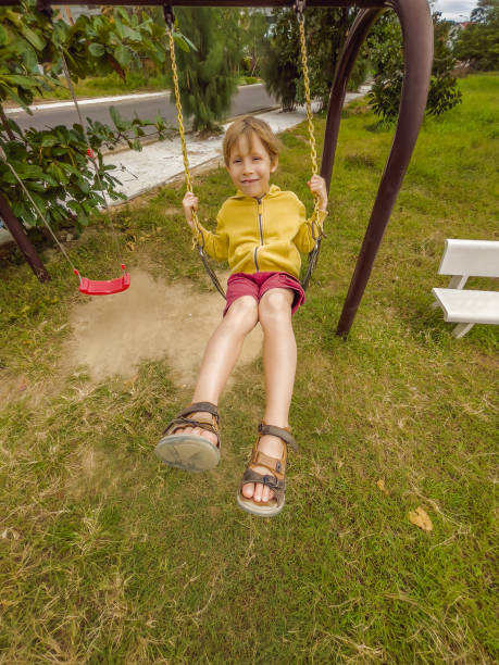 istock Little cute boy having fun on chain swings 1521803317