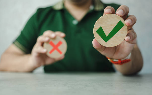 istock Wooden blocks show the right check marks and are wrong by hand man, decisions and thinking. Approval theme. 1521805497