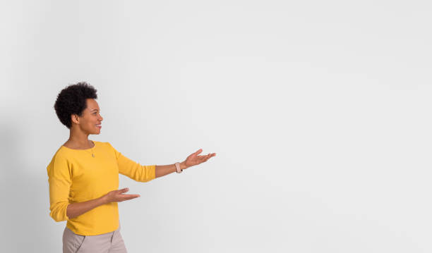 istock Young businesswoman presenting new product over copy space while standing on white background 1521807136