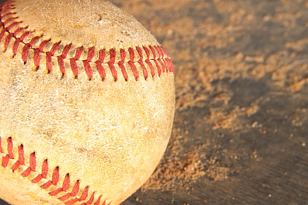 Old Grunge Baseball On Wood and Dirt Background A baseball sitting on a shelf in a dugout at the local little league field. leasure games stock pictures, royalty-free photos & images