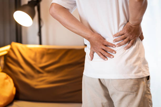 istock Sad asian man having a backache after sleep,Stressed people suffering from low back pain,lumbar disc herniation,musculotendinous strain,touching his back with hands,health care,medical concept 1521871700