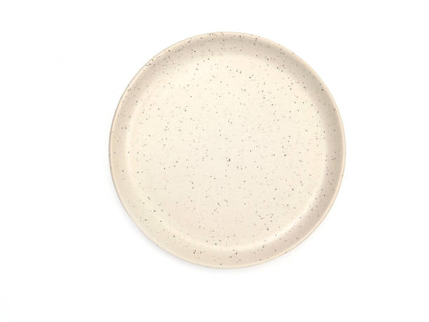 istock Top view, empty beige round ceramic plate with dotted isolated on a white background. 1521880674