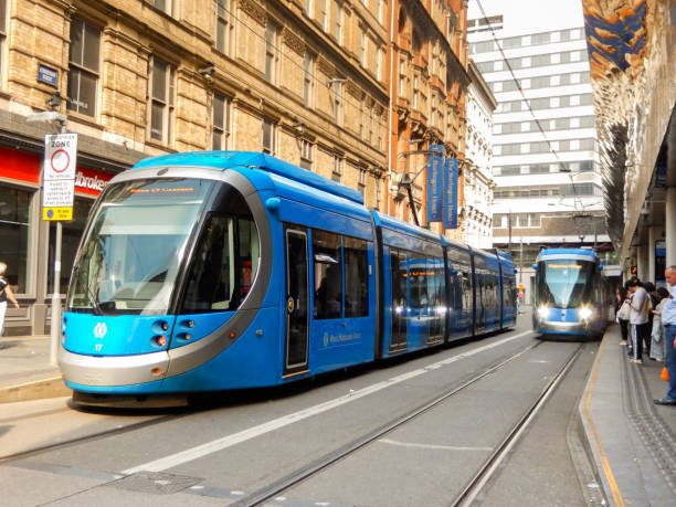 Birmingham, England, UK - 12 June 2023: Electric tram at a tram stop in Birmingham city centre with another tram approaching.