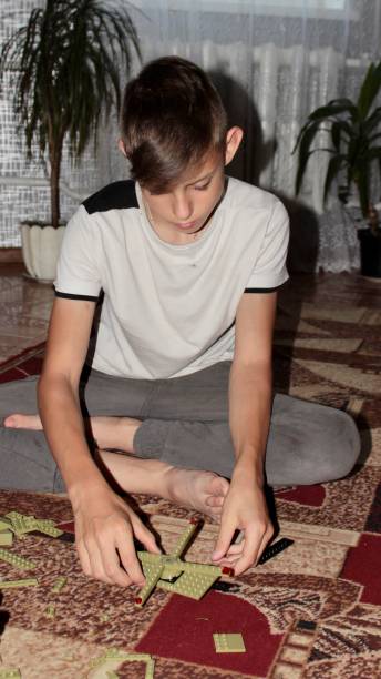 istock in the evening, the boy is engrossed in the game, playing and assembling a constructor on a mat on the floor 1521955529