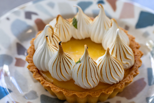 cooking dessert - delicious lemon tarts and classic meringue topping on a blue background\