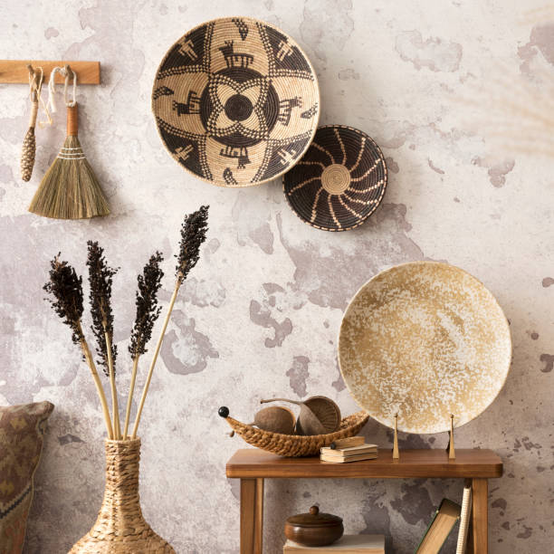istock Creative composition of ethnic living room interior with design, colorful baskets, rattan sideboard,  wooden consola, round plate, gray concrete wall, and personal accessories. Home decor. Template. 1521996832