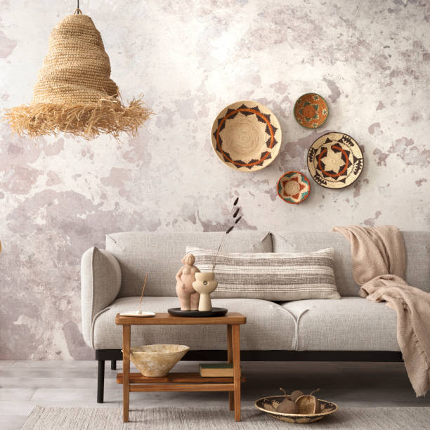 istock Interior design of ethnic composition living room interior with grey sofa, colorful wicker, boho straw lamp, gray concrete wall, bench and personal accessories. Home decor. Template. 1521997906