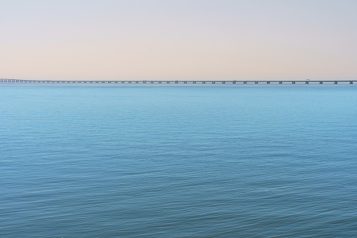 tranquil waterway with calm water and a distant bridge spanning the horizon symbol of modern engineering