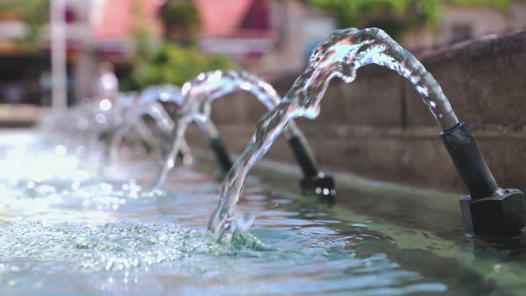 Water Streams Pouring From Fountain. Water splashes and blurred background. 4K resolution. Selective focus