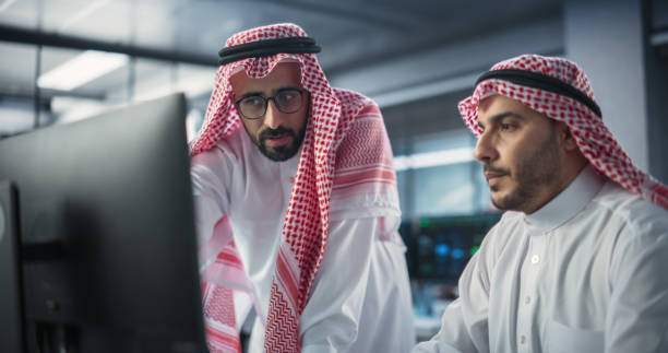 istock Team of Two Multiethnic Gulf Software Developers Talk, Discuss and Collaborate on an AI Project. Empowered Young Middle Eastern Specialists Work on Digital E-Commerce Startup Business 1522083254