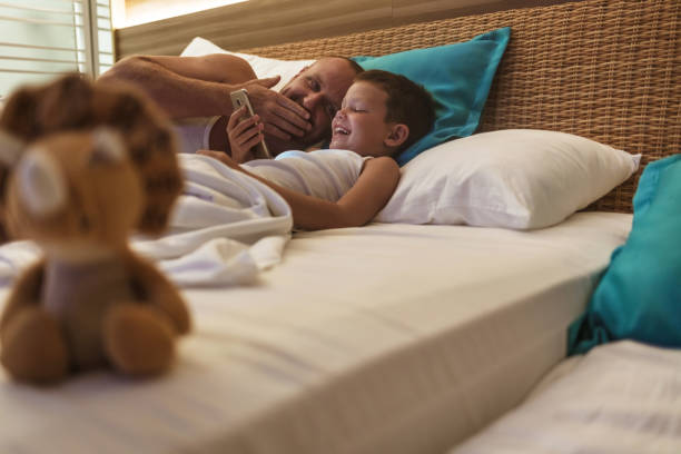 istock Shot of a young father using a mobile with his son at home at night. 1522083645