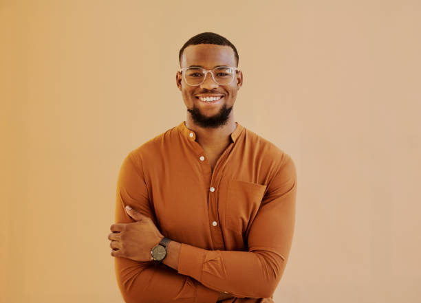 Young businessman standing while smiling at camera with copy space. Stock photo