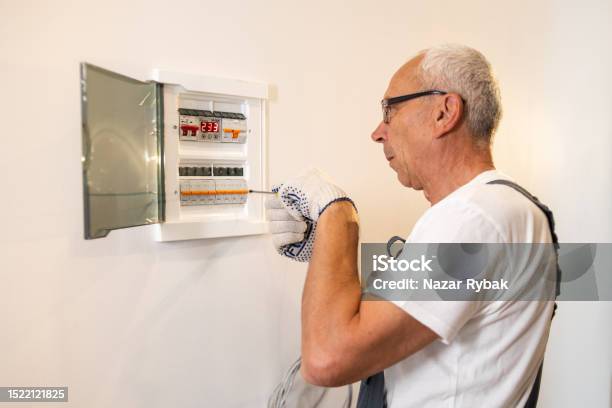 A Professional Electrician Worker Services An Electrical Switchboard At Home Stock Photo - Download Image Now