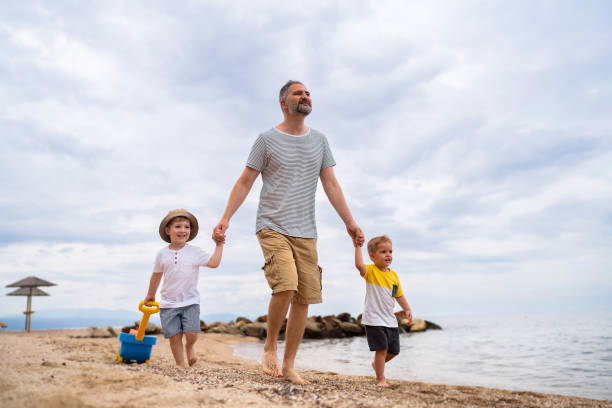 Father with two sons on the beach.