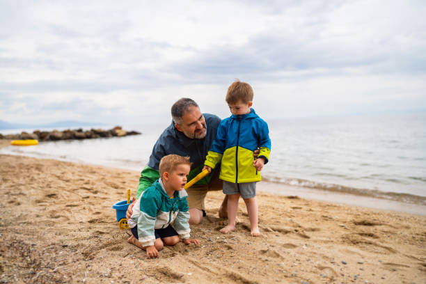istock Father with two sons on the beach 1522176867