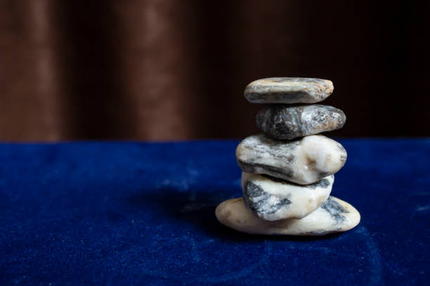 istock White stones stack on blue velvet and brown courtains, serene zen backdrop for wellness 1522180126