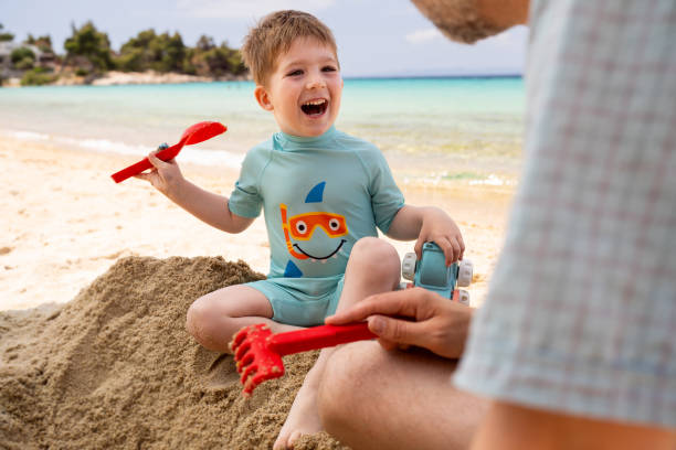 istock Little boy playing on the beach with his father 1522182259