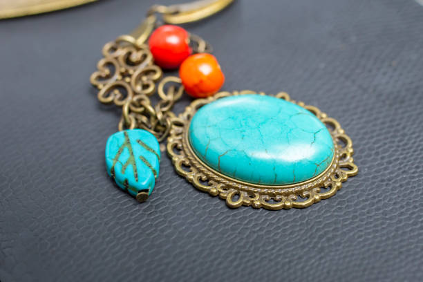 istock turquoise stone brooch  on black texture, soft focus 1522186041