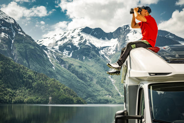 istock Exploring Scenic Norwegian Nature Using Binoculars While Seating on a Roof of His Camper Van 1522189298