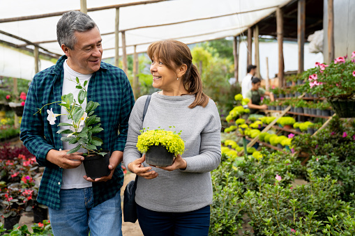 Mature Latin American couple shopping at a plant nursery and looking very happy - lifestyle concepts