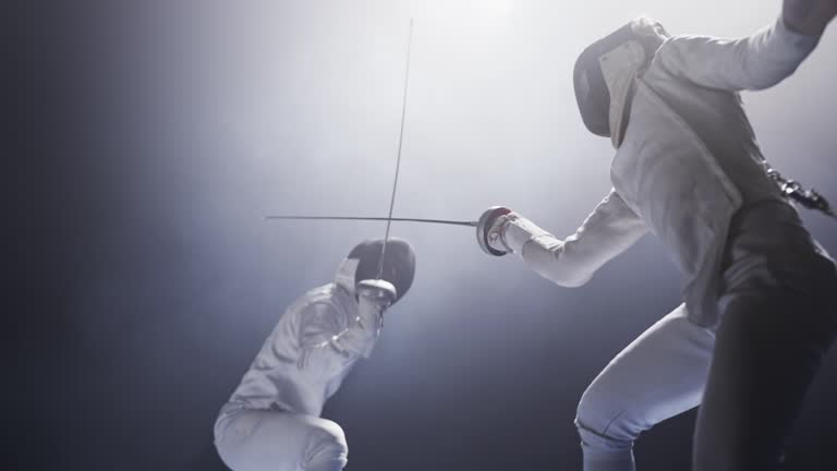 Two professional fencers clashing in combat. Attacking and defending