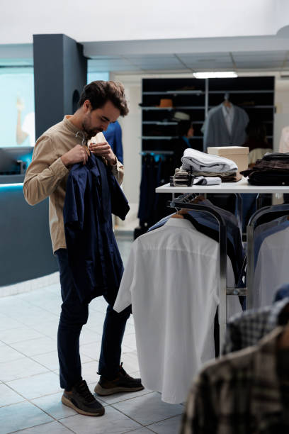 istock Store customer holding shirt to body 1522228963