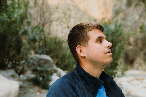 Side view of handsome male tourist walking in the beautiful canyon in the mountains of Lycia, South Turkey