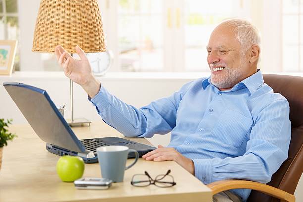Rir idoso usando computador portátil - fotografia de stock