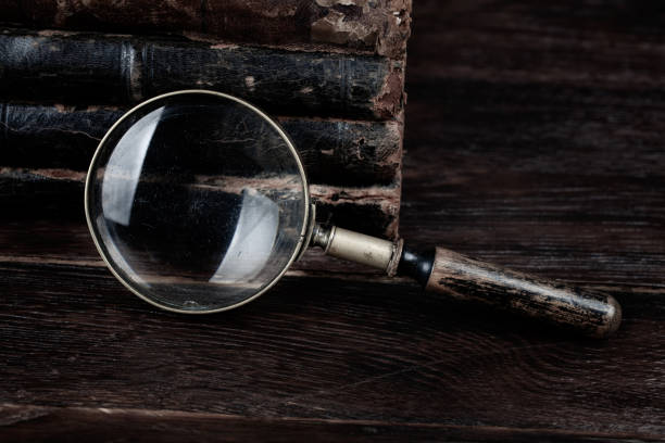 istock Old vintage magnifying glass with books on table 1522285883