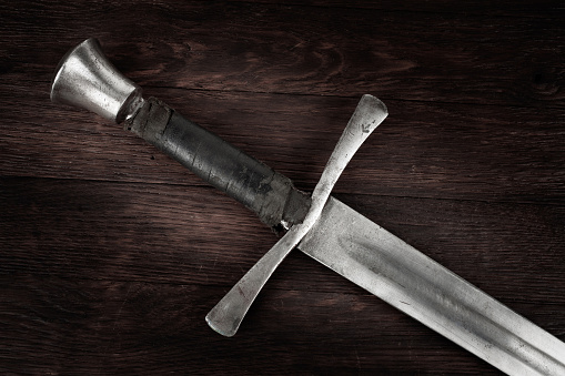 Medieval vintage sword on wooden backgrond.
