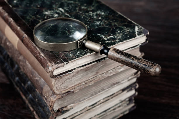 istock Old vintage magnifying glass with books on table 1522292256