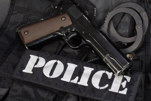 Police handgun with handcuffs on black uniform