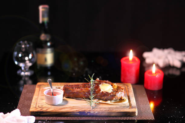 Rib eye steak on the New Year's table. Steak rib eye roast on a wooden board with sauce and salt. Beef steak on wooden plate.