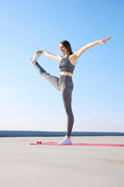istock Young flexible, sportive woman in comfortable sportswear doing stretching exercises, training outdoors on warm sunny day 1522406310
