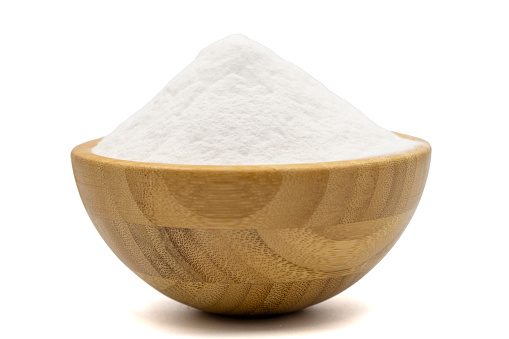 Sodium bicarbonate or baking soda isolated on white background. Sodium bicarbonate powder in wooden bowl
