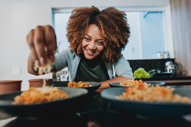 istock Woman putting grated cheese on macaroni 1522412578