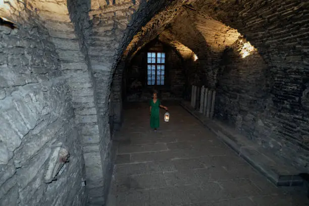 Photo of Beautiful girl in a dress inside the old castle in the old town.