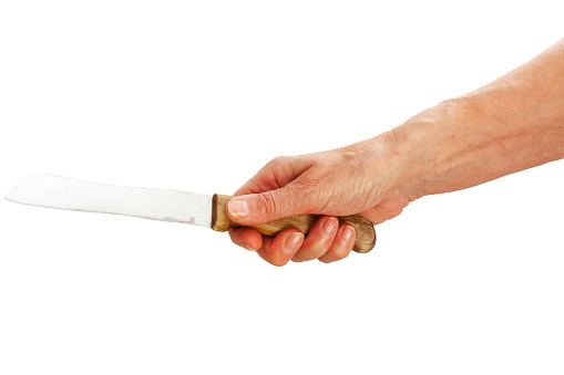Mature woman's hand holding a kitchen knife