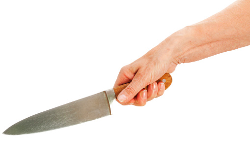 Mature woman's hand holding a big sharp kitchen knife