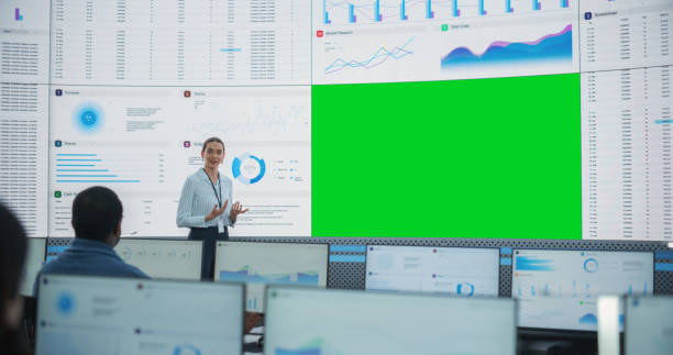 istock Caucasian Female Data Scientist Giving Presentation On Big Digital Screen With Green Screen Chromakey In Monitoring Office. Team Of Deep Learning Company Employees Listening Behind Desktop Computers. 1522425565