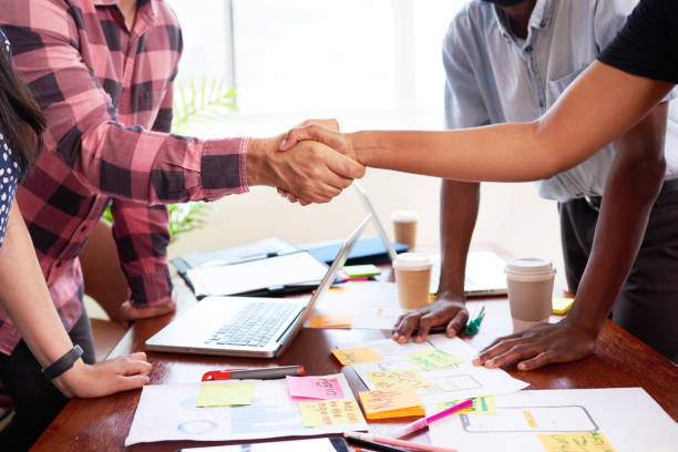 istock Close up of two tech engineers shaking hands at design launch meeting mobile app 1522450221