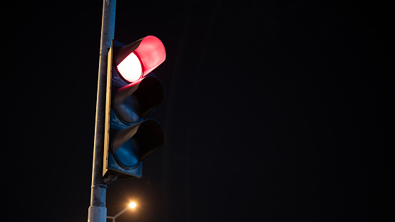 Red traffic light at midnight