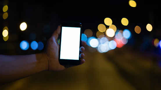 Man hand using smartphone with white screen at night