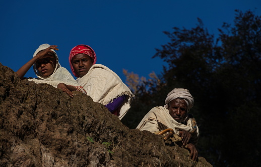 Lalibela, Ethiopia - January 5, 2023: Ethiopian people standing on the grounds above the famous Rock-Hewn Church of Biete Medhane Alem. The eleven Rock-hewn Churches of Lalibela are monolithic churches located in the Western Ethiopian Highlands near the town of Lalibela, named after the late-12th and early-13th century King Gebre Mesqel Lalibela. Lalibela is an UNESCO World Heritage Site.