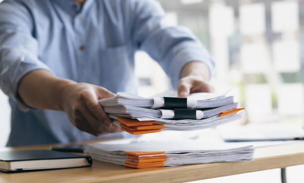 istock Business Documents, Auditor businessman checking working in stack of paper files for searching document legal prepare paperwork or report, accountant Documents data contract partner deal in workplace. 1522476592