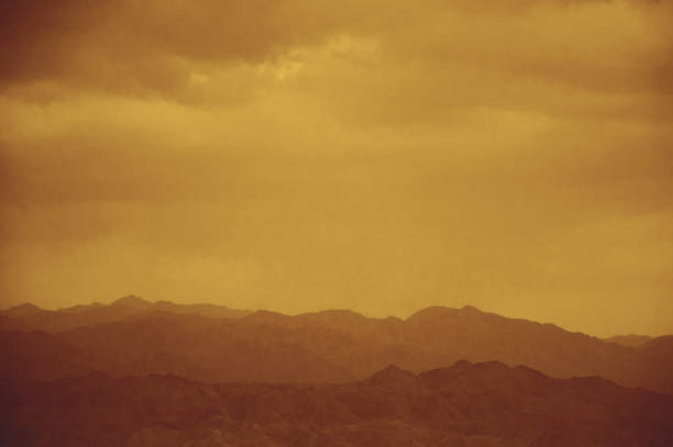 Sandstorm over mountains in desert. Retro toned photo.