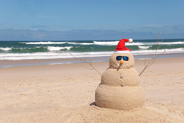 boneco de neve resiste ao processo de fusão - christmas beach sun tropical climate imagens e fotografias de stock